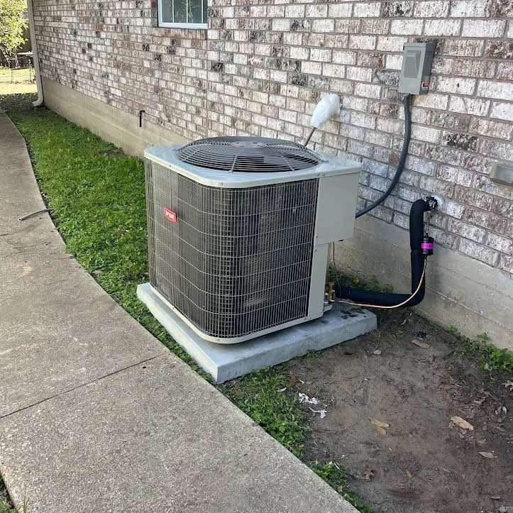 Outdoor air conditioning equipment beside a brick home, pictured on Brazos Air’s current website