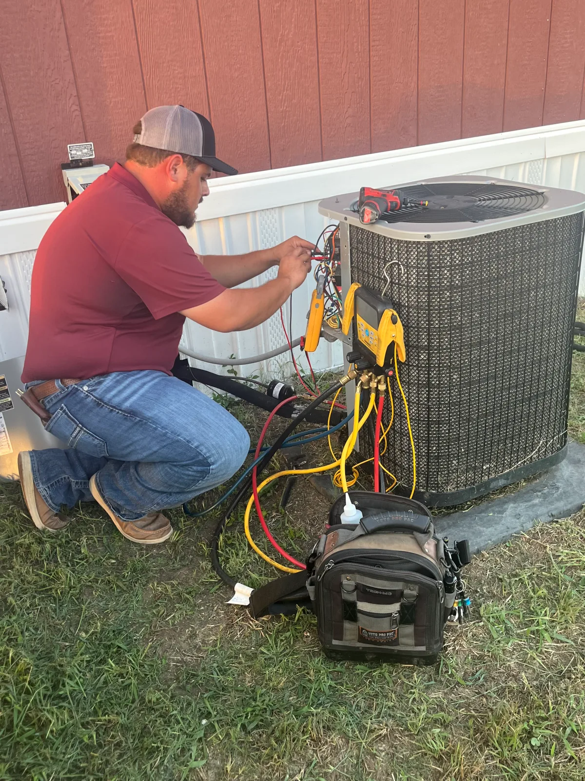A technician servicing an outdoor air conditioning unit, from DJ’s AC and Heating’s public project gallery
